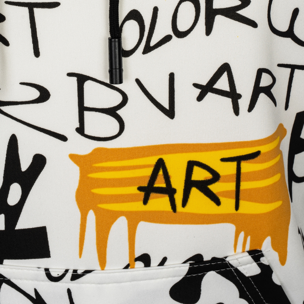 Close-up of a white hoodie featuring a black graffiti-style graphic print with the word 'ART' inside a yellow paint-drip shape.