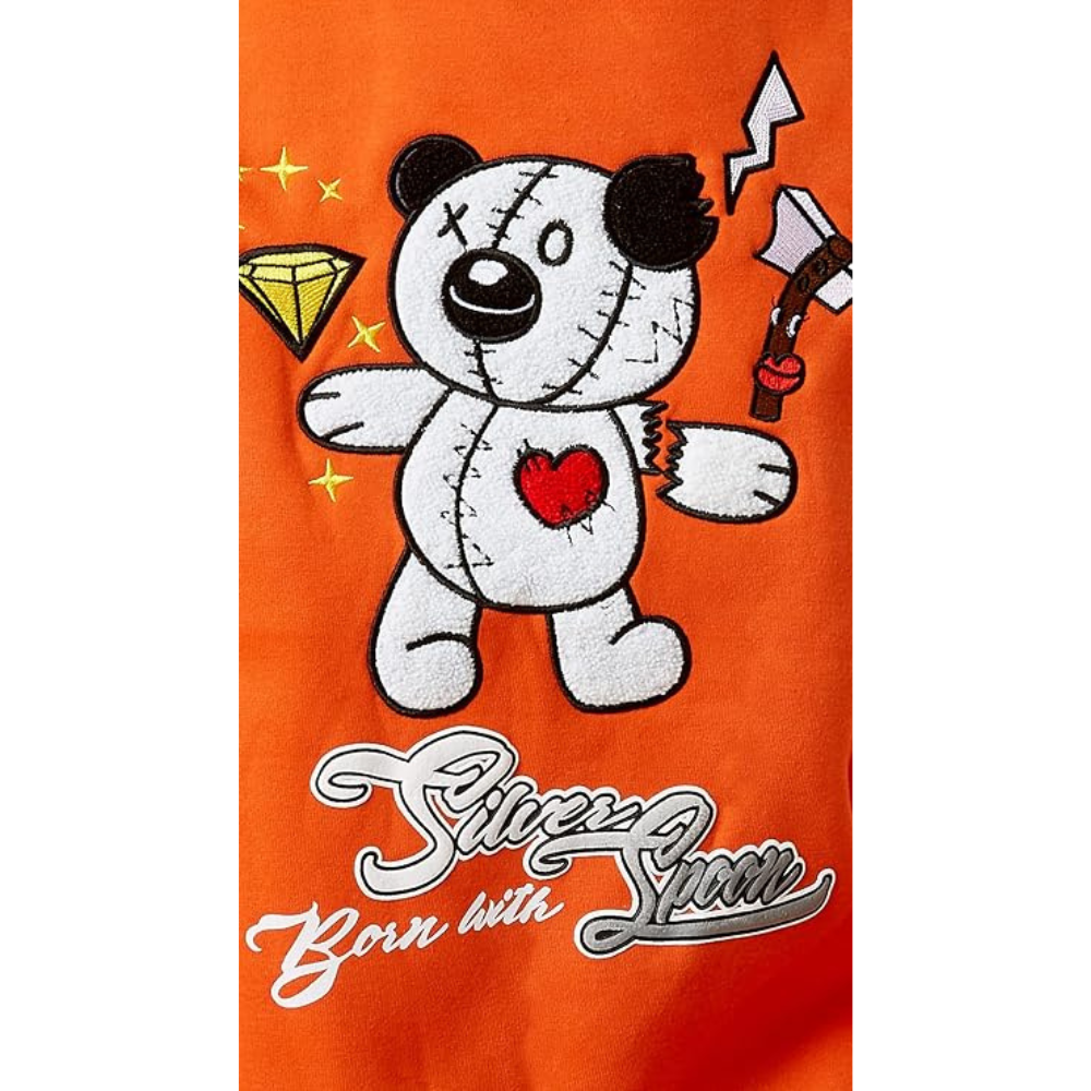 An orange graphic print featuring a white stitched teddy bear with a red heart on its chest, holding a silver axe, alongside a yellow diamond and the text 'Silencer Born with Sin' in stylized white and silver lettering.