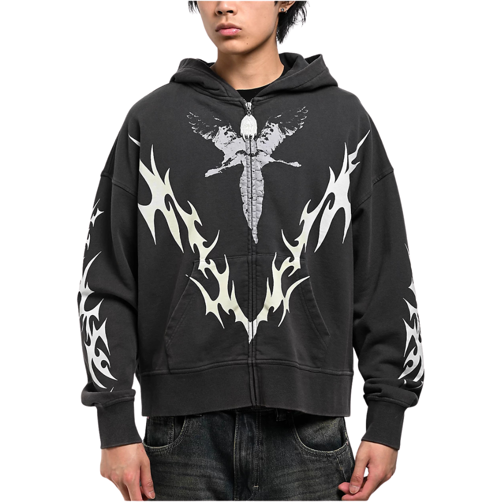A person wearing a black zip-up hoodie with a large white winged dagger graphic on the chest and white flame-like sleeve prints, paired with dark jeans against a plain white background.