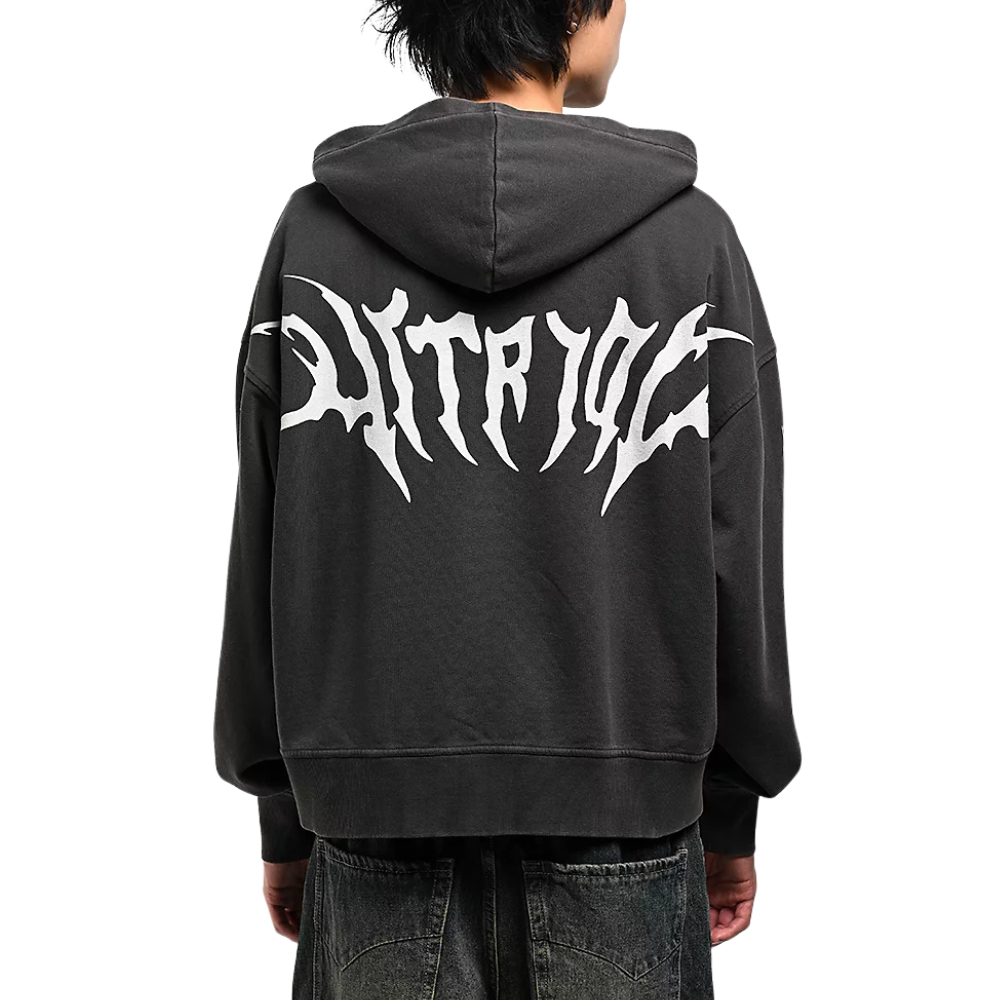 A person shown from the back wearing a dark charcoal gray hoodie with a large white stylized graphic across the back, paired with dark jeans against a plain white background.