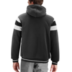A man viewed from the back wearing a dark charcoal gray hooded sweatshirt with white athletic stripes on the shoulders and cuffs, paired with gray pants, against a plain white background.
